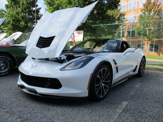 A white sports car with its hood open.
