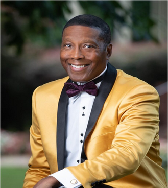 A man in a yellow jacket and bow tie.