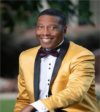 A man in a yellow jacket and bow tie.